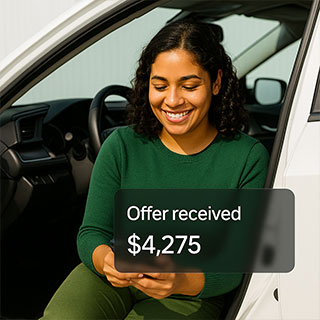 Woman sitting in vehicle receiving offer from Sell My Car Online website